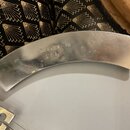 Detail kovového, oblého komponentu v stříbrné barvě. Na povrchu je vyražen nápis MASTERTON - 88 U.S.A. Povrch vykazuje drobné škrábance a známky opot…