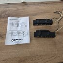 Na fotografii jsou dva černé elektrické snímače s šestnácti viditelnými póly, z nichž každý má dvě kovové úchytky. K snímačům vedou několik barevných…