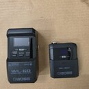 Černý bezdrátový systém značky BOSS. Na levém zařízení je nápis WL-60 WIRELESS SYSTEM a tlačítka CABLE TONE, ENTER, SCAN a CH. Pravé menší zařízení n…