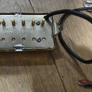 Kovový snímač k elektrické kytáře s mosaznými póly a černým kabelem. Na spodní straně je nápis DIMARZIO PICKUPS MADE IN U.S.A. a nálepka s označením…