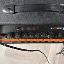 Horní ovládací panel černého basového komba s oranžovým pruhem. Na panelu je bílý nápis ORANGE CRUSH BASS 50 a řada kontrolních LED diod s označením…