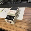 Bílý kytarový ladič značky BOSS s černým pedalem. Na horní části je nápis Chromatic Tuner TU-3 a označení vstupů INPUT a OUTPUT. Přístroj vykazuje zn…
