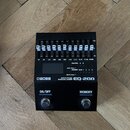 Černý grafický ekvalizér s nápisy BOSS, GRAPHIC EQUALIZER a EQ-200. Horní panel obsahuje řadu posuvníků s označením frekvencí od 30 do 12.8k a ovlada…
