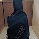 Černý polotvrdý obal na kytaru umístěný na stojanu. Na spodní části je velký šikmý nápis RITTER a menší text R-2030 G / Deluxe Gig. Povrch materiálu…