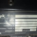 Fotografie detailu stříbrného štítku na černém zařízení. Štítek obsahuje logo Zeck a nápisy SPEAKER SYSTEM ASP 21522, SER.NR. 970415, POWER CAPACITY…