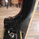 Detail krku a horní části trupu černé kytary. Lak je v místě spoje hmatníku s tělem odepsaný a vykazuje známky opotřebení. V horní části je vidět otv…