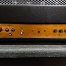 Detail zadní strany kytarového zesilovače s žlutým kovovým panelem. Na panelu jsou nápisy SELECTOR, OUTPUT, SPEAKERS, NFB, POWER FULL HALF, BIAS TEST…