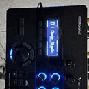 Černý elektronický modul V-Drums značky Roland. Na displeji je vidět nápis „01 Deep Studio“. Modul obsahuje několik ovládacích knofíků s popisky TUNI…