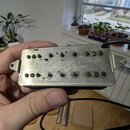 Kytarový snímač s kovovým krytem stříbrné barvy. Na krytu je vyryt nápis Bare Knuckle Pickups a pod ním Handwound in the UK. Povrch krytu vykazuje zn…
