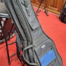 Černý polotvrdý pouzdro (gig bag) na hudební nástroj s několika zipovými kapsami. Na přední části je viditelné bílé oválné logo s nápisem "dr. many".…
