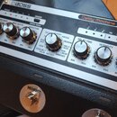 Stříbrný efektový pedál Delay Machine DM-101 značky BOSS. Na horním panelu jsou umístěny otočné oválné knoflíky s popisky MOD RATE, MOD DEPTH, VARIAT…