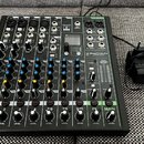Černý mixážní pult s bílými a barevnými popisky. Na přístroji je viditelné logo PROXTON s označením modelu PRO-10.4+. K mixážní pultu je připojen čer…