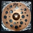 Bronzový činely s mnoha vyvrtanými otvory různých velikostí, zabalený v průhledné plastové fólii. Na povrchu je černý nápis pAiste a logo PST X, pod…
