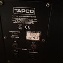 Fotografie zachycuje zadní štít černého reproduktoru. Je na něm bílý nápis TAPCO, označení modelu TAPCO 69 SERIES / 6915 a text DESIGNED IN WOODINVIL…