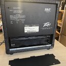 Zadní strana černého komba s texturovaným povrchem a přívěhem. Na zadním panelu je bílý nápis SOLO™ PORTABLE SOUND SYSTEM a logo Peavey. Štítek obsah…