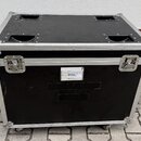 Černý transportní kufr s hliníkovými hranami a kovovými rohy. Na přední straně jsou dva kovové zámky a bílá nálepka s textem: "Portable ADA / 12A / 2…
