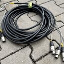 Svijitý svazek černých kabelů s šedými odbočkami zakončenými konektory XLR. Na konektorech jsou viditelné bílé čísla 1, 2, 3 a 4. Kabel je svázaný žl…