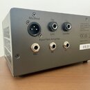 Zadní strana šedého elektronického zařízení s několika konektory. V horní části jsou tři výstupy označené jako MicMod, Out Line a Out Speaker. Spodní…