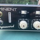 Detail čelního panelu černého elektronického přístroje s bílými nápisy EMINENT a Synacord. Jsou zde vidět dva přepínače s popisky Instr. 1 a Instr. 2…