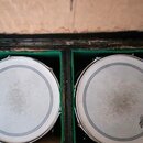 Dvě bílé bubnové membrány umístěné v zeleně vystlaném černém kufru. Na obou membránách je viditelné logo REMO s ikonou koruny a vlivem používání jsou…