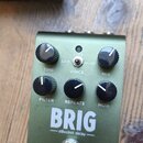 Zelený efekt pedál s nápisy BRIG a dBucket delay. Na spodní části je logo strymon. Pedál má šest černých otočných ovladačů s popisky TIME, VOICE, MIX…