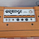 Kytarový zesilovač v oranžovém vinylovém potahu s černými kovovými rohy. Na předním bílém panelu je nápis ORANGE TINY TERROR a logo s obrazkem. Panel…