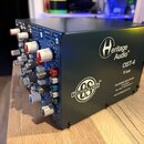 Tmavě modré rackové šasi pro moduly 500 řady. Na pravém boku je bílý nápis Heritage Audio, model OST-4 V2.0 a logo TECHNOLOGY OS TM s doplňujícím tex…