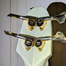 Detail hlavy světle zelené kytary s kovovými ladicími mechanismy. Na každém z mechanismů je černý oválný štítek s nápisem YAMAHA JAPAN. Povrch laku j…