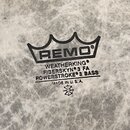 Detailní záběr na bílou bubnovou blánu s mramorovým vzorem. Uprostřed je černý nápis REMO v koruně a text WEATHERKING, FIBERSKYN 3 FA, POWERSTROKE 3…
