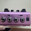 Záběr na zadní panel fialového efektpedálu s kovovým povrchem. Jsou zde viditelné konektory s popisky IN, OUT L, OUT R a EXP/MIDI, přepínač INPUT s p…