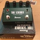 Zelený efekt pedál s kovovým šasi a čtyřmi černými ovládacími knoflíky. Na přední straně je bílý nápis TUBE SCREAMER, Overdrive Pro TS808DX a logo Ib…