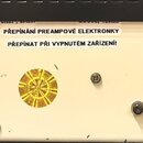 Detail zadní strany bílého elektronického zařízení. Jsou zde dva výstupy s nápisem SPEAKER 1x8Ω or 2x16Ω, napájecí konektor s označením 230V AC a kul…
