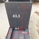 Otevřený transportní kufr z černého materiálu s hliníkovými hranami. Vnitřek je vyložen tmavou polstrovací výplní. Na fotce jsou červenými šipkami a…