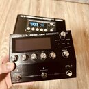 Černý efektový procesor s nápisem BOSS GT-1000CORE GUITAR EFFECTS PROCESSOR. Zařízení má digitální displej, několik stříbrných oválových tlačítek s č…