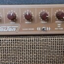 Kytarový zesilovač s hnědým ovládacím panelem a pletenou mřížkou reproduktoru. Na panelu je nápis Solton, CLEAR-SOUND a HOT-TUBE. Ovládání tvoří šest…