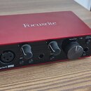 Červený audio rozhraní s černým předním panelem. Na horní straně je bílý nápis Focusrite a v levém dolním rohu nápisy Scarlett Solo. Zařízení obsahuj…