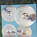 Sada čtyř mosazných činelů značky Paiste z řady pst 3. Na činelech jsou viditelné nápisy paiste a pst 3, přičemž u největšího je uveden text 20 RIDE.…