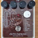 Hnědý kytarový efekt s bílým rámem a nápisem electro-harmonix NEW YORK CITY, USA. Na horní straně jsou čtyři černé ovládací knoflíky s popisky DRY, V…