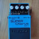 Modrý kytarový efekt s nápisy SUPER Chorus a CH-1. Na spodní části je černý gumový pedal s vyraženým logem BOSS. Horní panel obsahuje čtyři bílé otoč…