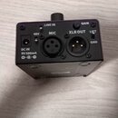 Černý kompaktní elektronický přístroj s kovovým povrchem. Na zadním panelu jsou konektory a nápisy: DC IN 9V 500mA, 48V, LINE IN MIC (XLR vstup), GAI…