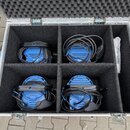 Otevřený hliníkový transportní kufr s černým polstrováním, který je rozdělen na čtyři přihrádky. V každé přihrádce se nachází jeden modrý kulatý přís…