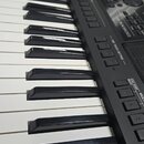 Černý digitální klavír s bílými a černými klávesami. Na ovládacím panelu je viditelný nápis SX800 a označení ONE TOUCH SETTING. Povrch nástroje je v…