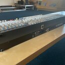 Černý mixážní pult s kovovým šasi a řadou bílých a stříbrných ovratových knoflíků. Na pravém boku je bílý nápis ALLEN&HEATH a vedle něj označení PA28…