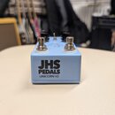 Světle modrý efekt pedál s nápisy JHS PEDALS a UNICORN V2. Na horní straně jsou dva kovové spínače a několik ovládacích knoflíků. Povrch pedálu vypad…