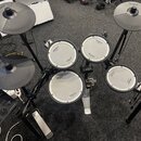 Elektronická bicí souprava značky Roland v černé barvě. Na čelech padů a na činelech je vidět logo Roland, u padů jsou dále nápisy V-Drums a V-Drum.…