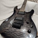 Elektrická kytara s černým lakem a viditnou strukturou plamenového javoru na topu. Nástroj má dva humbuckery, fixní most s černým povrchem a dva ovlá…