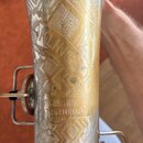Detail kovového trubice nástroje se složitou rytinou a zlatavým povrchem. Na povrchu je vyryto „KLINGSOR“ a níže text „KARL HOMMERSCHMIDT WATZKENREUT…