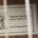 Bílá štítková nálepka s černým textem a ilustrací ženy v šatech. Je na ní uveden nápis Václav Svoboda, model: Master SP a text fecit Pragae 2014. Ští…