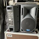Dva černé aktivní reproduktory z plastu, jeden z nich je natočen bokem a druhý čelem. Na boku prvního je bílý nápis OPERA LIVE 210 a logo dB technolo…