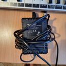 Černý síťový adaptér s napojeným kabelem. Na štítku je uveden nápis BEHRINGER POWER SUPPLY MODEL MXEU1, dále údaje INPUT: 230 VAC / 50 Hz / 250 mA a…